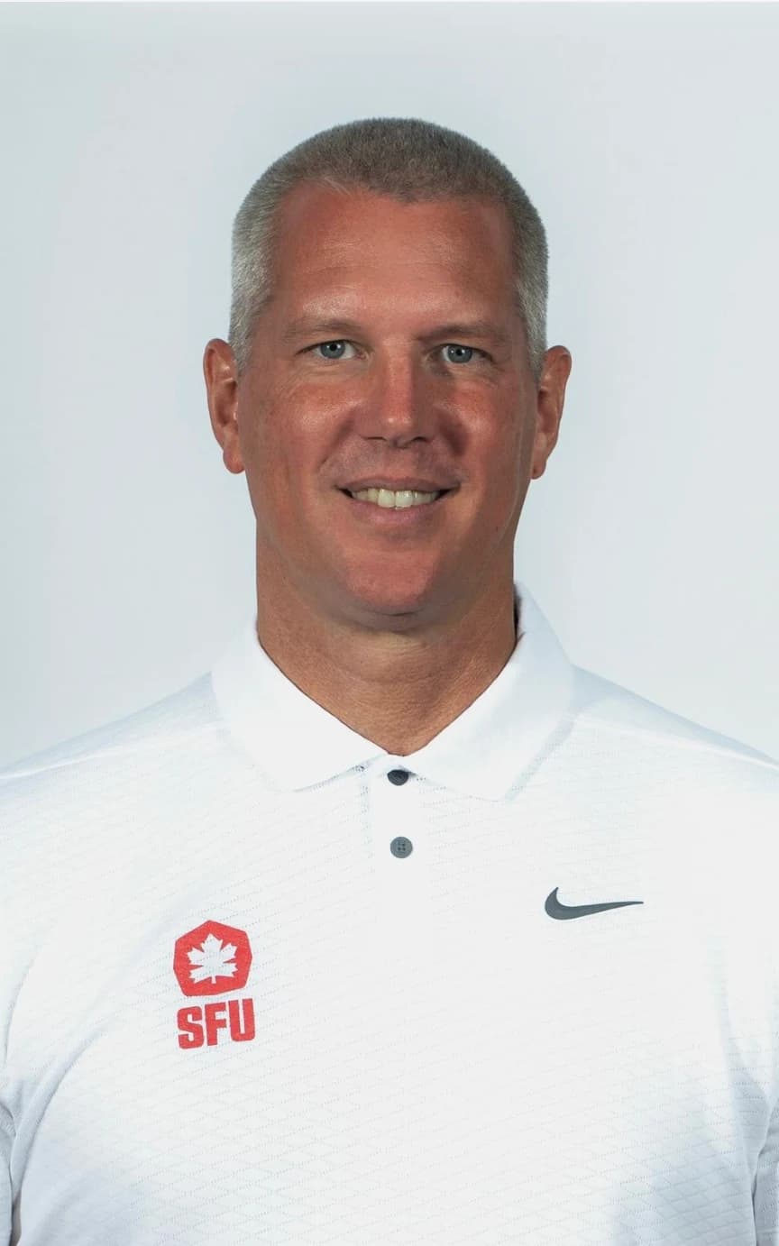 Steve Hanson wearing a white Simon Fraser basketball polo