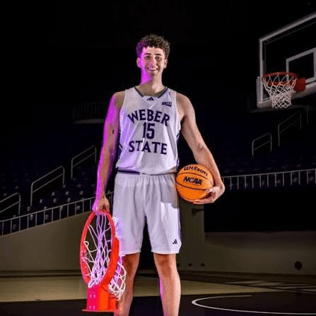 Declan Cutler holding a basketball in his Weber State number 15 uniform.