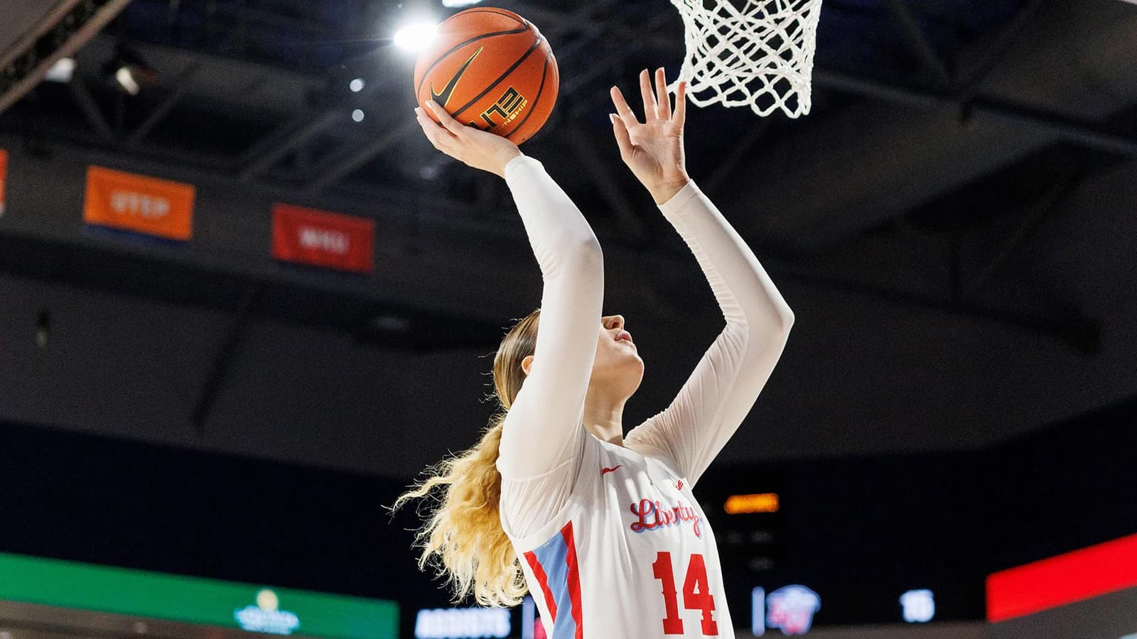 Axis mentor Emily Howard finishing at the basket in her white Liberty uniform.