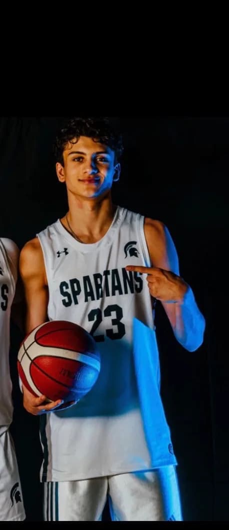 Daxton holding a basketball in a Spartans jersey