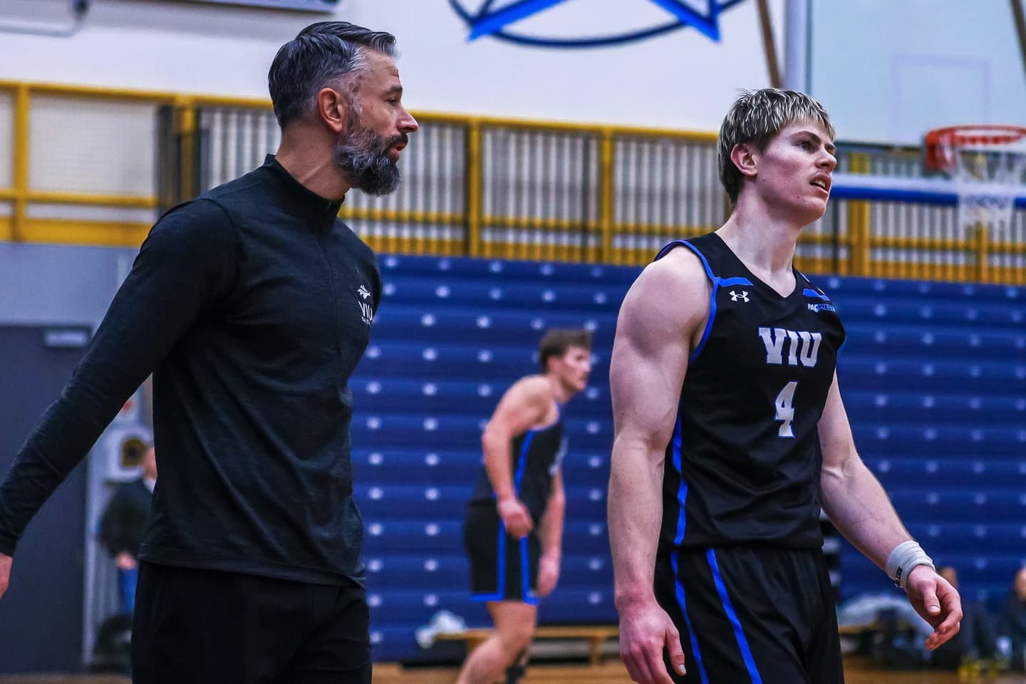Kye Kotapski-Tinga wearing the VIU Mariners number 4 jersey beside a coach