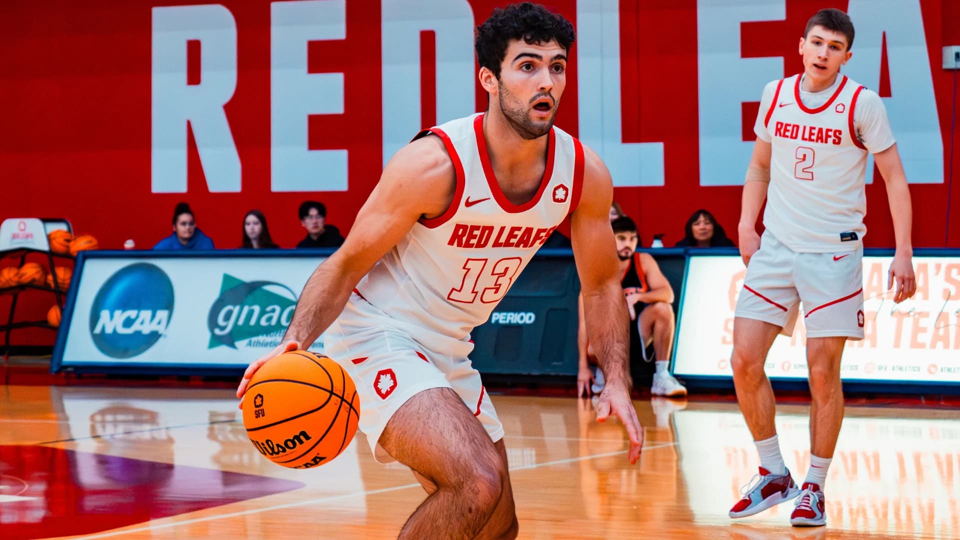 Matthys Van Bylandt dribbling in a white SFU number 13 uniform.